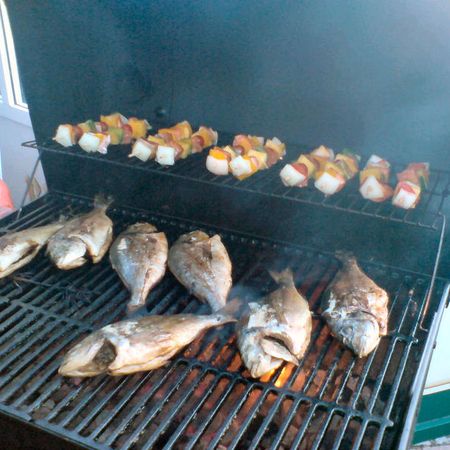 Frischer Fisch und Spieße werden gegrillt